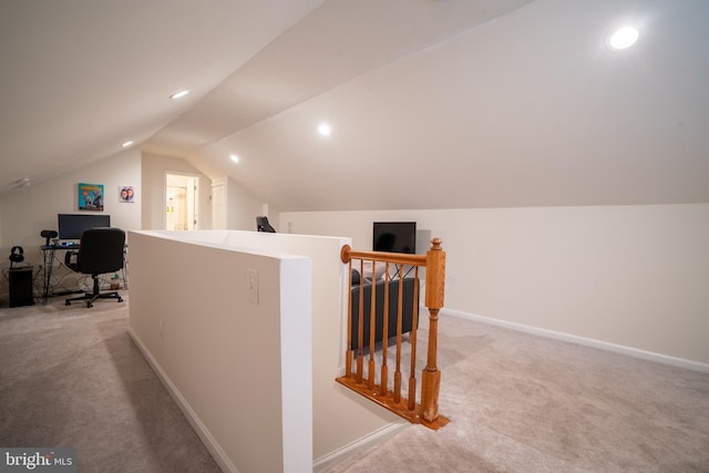 corridor with light colored carpet and lofted ceiling