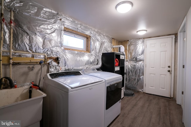 laundry room featuring sink, dark wood-type flooring, and washer and clothes dryer