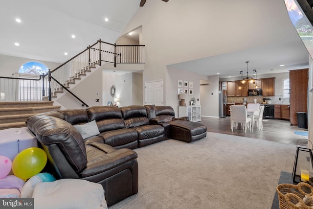 living room with high vaulted ceiling, a healthy amount of sunlight, and hardwood / wood-style flooring