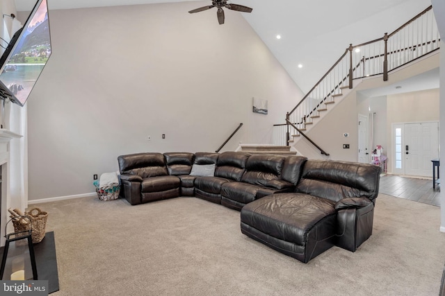 living room with ceiling fan, carpet floors, and high vaulted ceiling