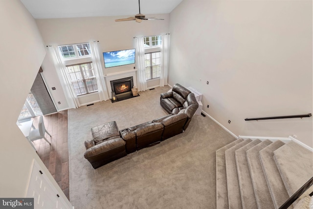 living room featuring ceiling fan, light colored carpet, and high vaulted ceiling