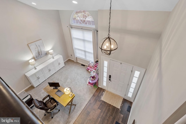 foyer entrance with dark hardwood / wood-style floors and an inviting chandelier