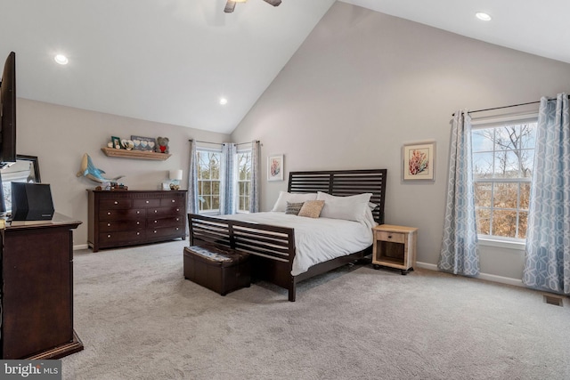 bedroom with ceiling fan, multiple windows, light colored carpet, and high vaulted ceiling