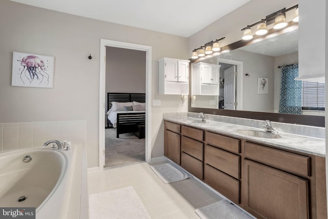 bathroom with a washtub, tile patterned floors, and vanity