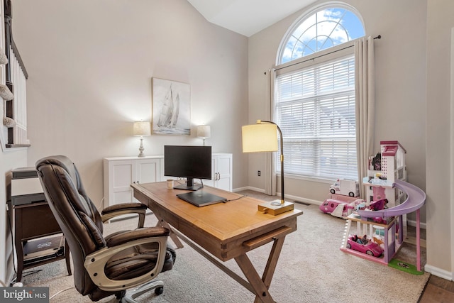 office space featuring lofted ceiling and a healthy amount of sunlight