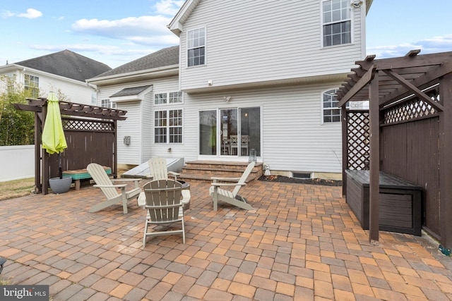 rear view of property featuring a pergola and a patio