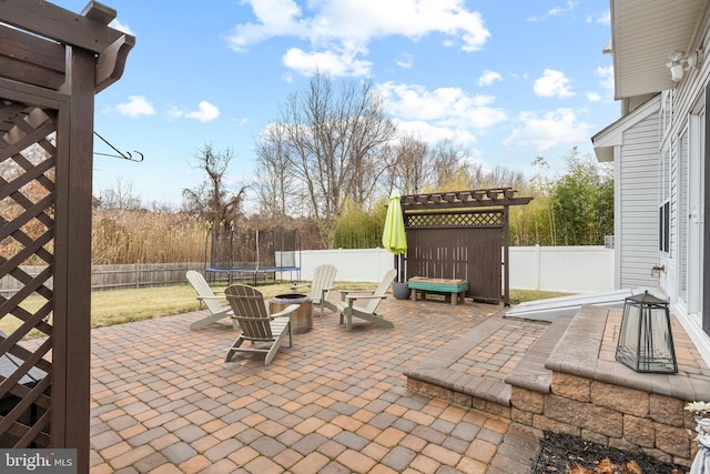 view of patio / terrace featuring a trampoline and a fire pit