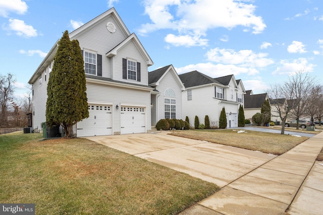 front of property with a front lawn, central AC unit, and a garage