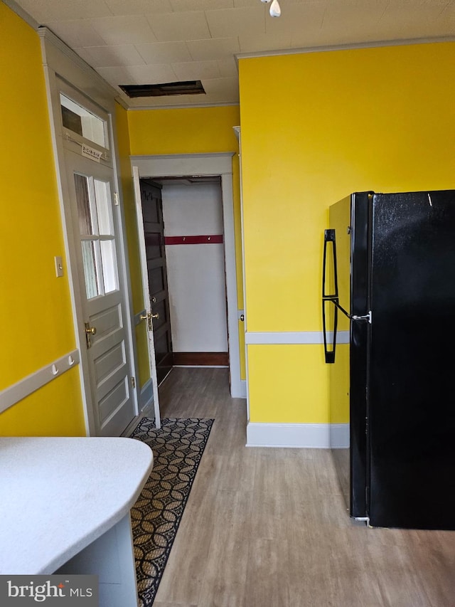 kitchen with black fridge and wood-type flooring