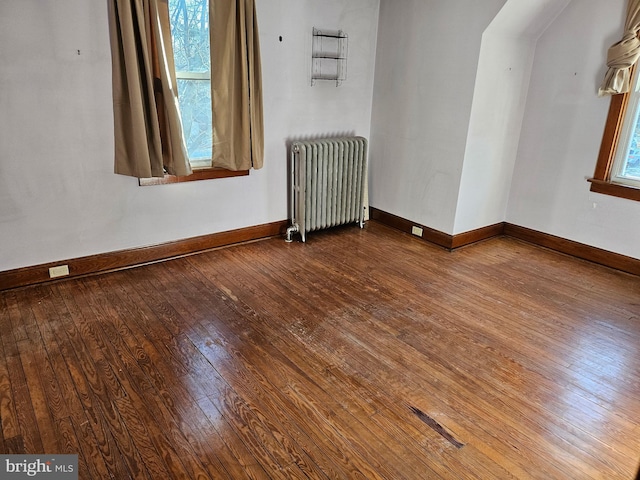 spare room with hardwood / wood-style floors and radiator heating unit