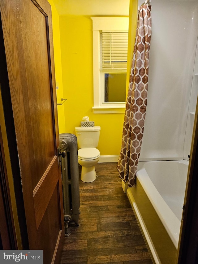 bathroom featuring hardwood / wood-style flooring, shower / bath combination with curtain, toilet, and radiator heating unit