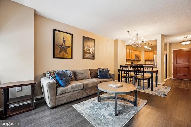 living room featuring a chandelier, a textured ceiling, and dark hardwood / wood-style flooring