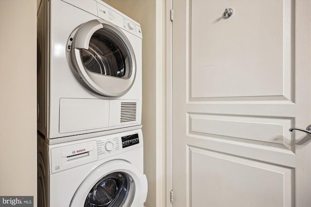 clothes washing area featuring stacked washer / dryer