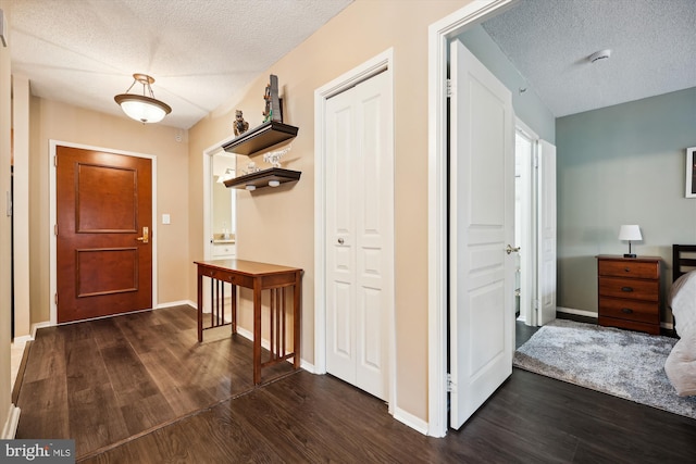 hallway with a textured ceiling and dark hardwood / wood-style flooring