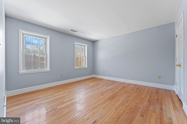 spare room featuring light hardwood / wood-style flooring and a healthy amount of sunlight