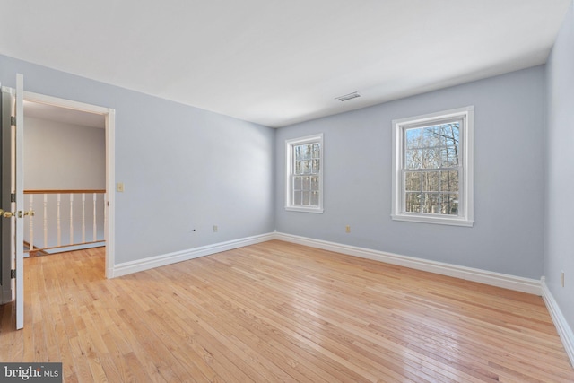 unfurnished room with a healthy amount of sunlight and light hardwood / wood-style flooring