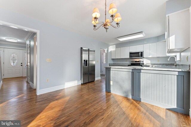 kitchen featuring sink, white cabinetry, stainless steel appliances, ornamental molding, and decorative light fixtures