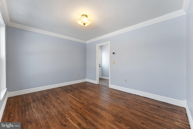 spare room with ornamental molding and dark hardwood / wood-style flooring