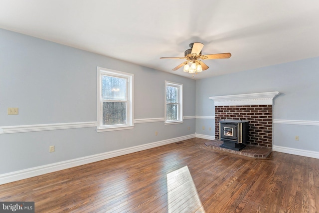 unfurnished living room featuring dark wood-type flooring, ceiling fan, and a wood stove