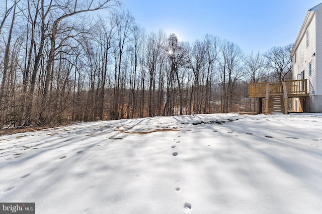 snowy yard featuring a deck