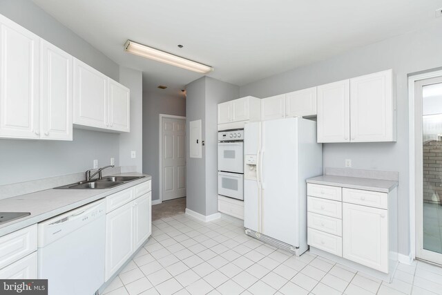 kitchen with light tile patterned floors, sink, white appliances, and white cabinets