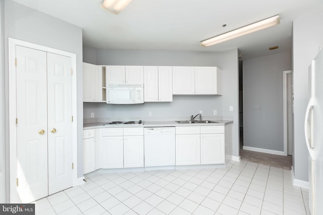 kitchen with sink, white appliances, and white cabinets