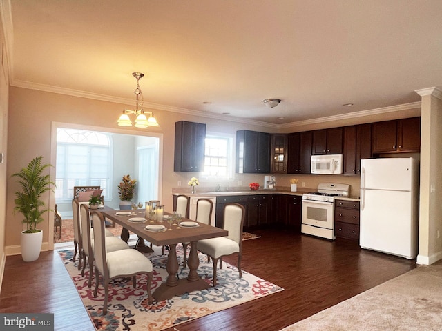 dining space featuring sink, ornamental molding, dark hardwood / wood-style floors, and a chandelier