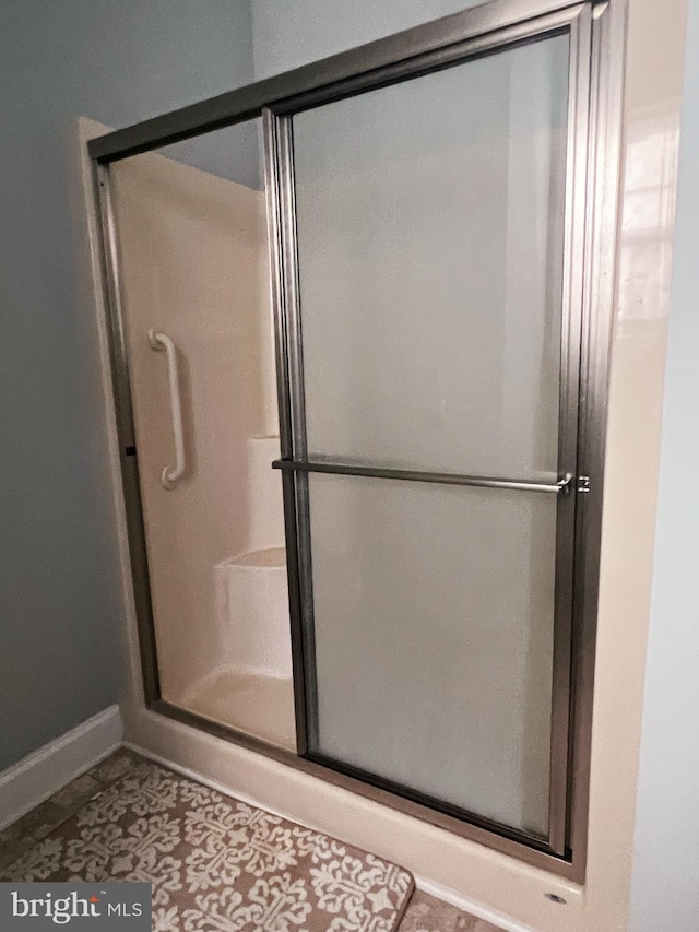 bathroom with tile patterned flooring and walk in shower