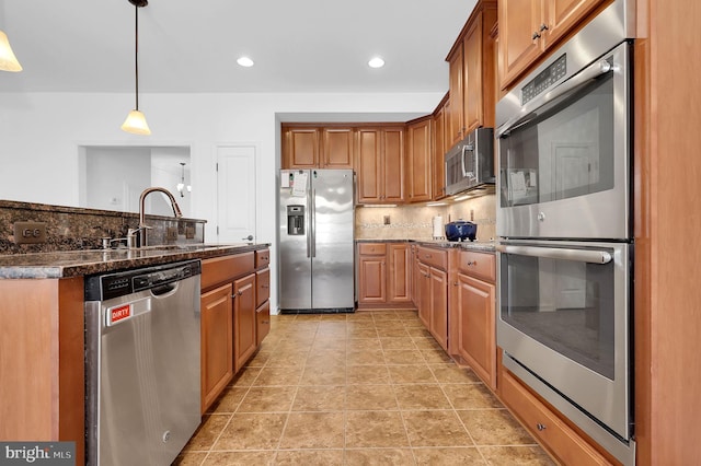 kitchen with sink, tasteful backsplash, decorative light fixtures, light tile patterned floors, and stainless steel appliances