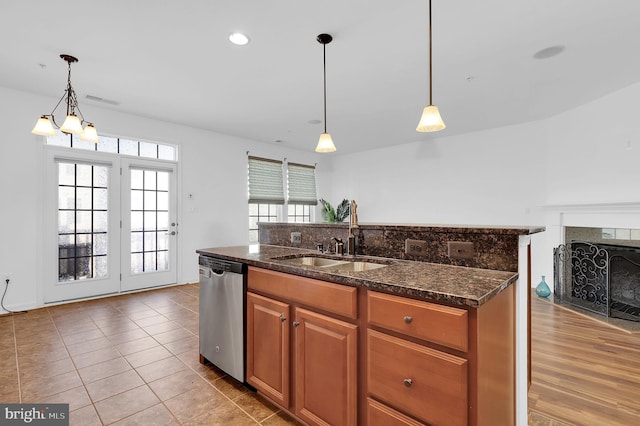 kitchen featuring dishwasher, sink, a healthy amount of sunlight, and decorative light fixtures