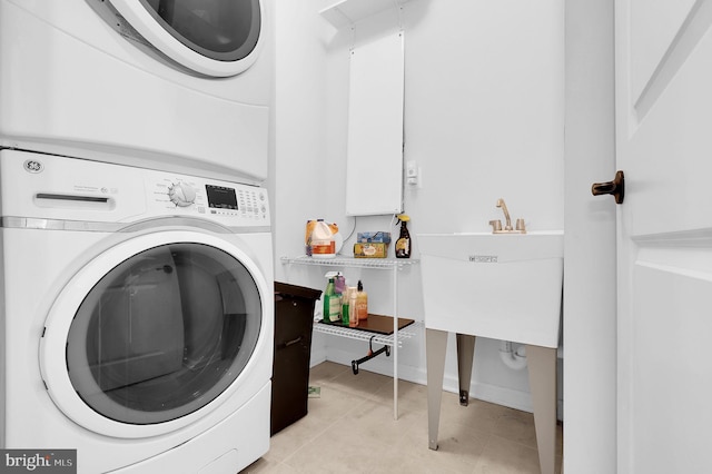 laundry room featuring stacked washer / drying machine, sink, and light tile patterned floors