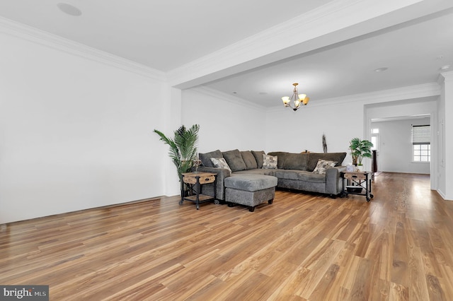 living room with hardwood / wood-style flooring, ornamental molding, and an inviting chandelier