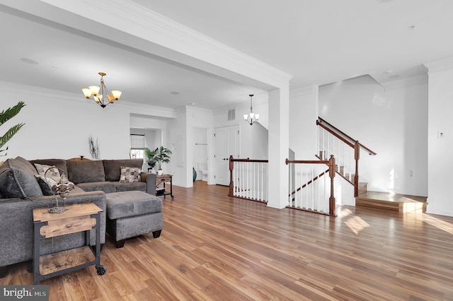 living room with an inviting chandelier, ornamental molding, and wood-type flooring