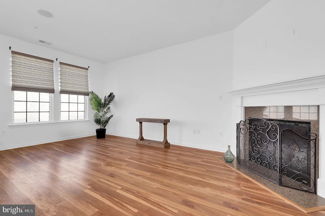 living room with hardwood / wood-style flooring and a tiled fireplace