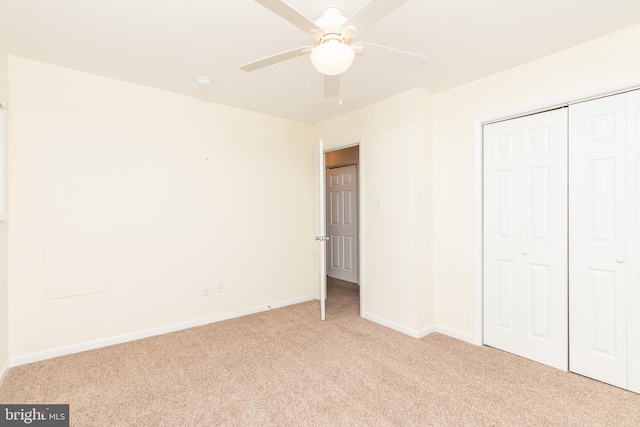 unfurnished bedroom featuring ceiling fan, light carpet, and a closet