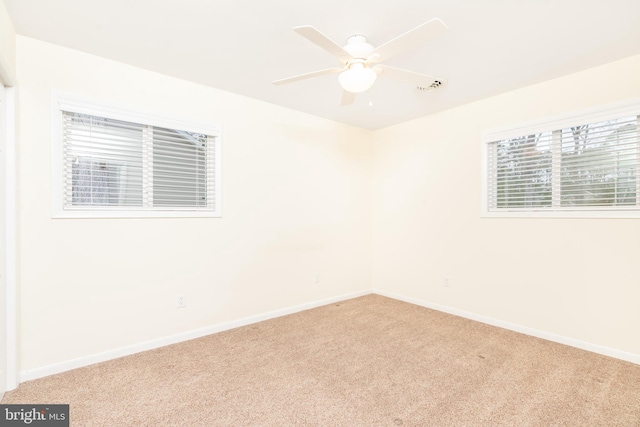 spare room with ceiling fan and carpet