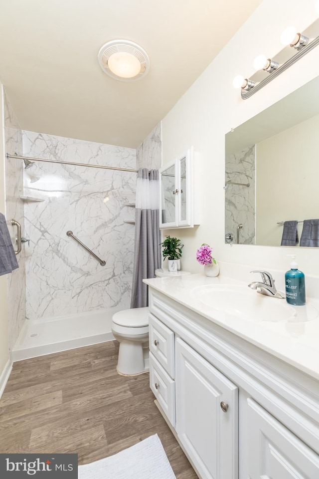 bathroom featuring walk in shower, vanity, toilet, and hardwood / wood-style flooring