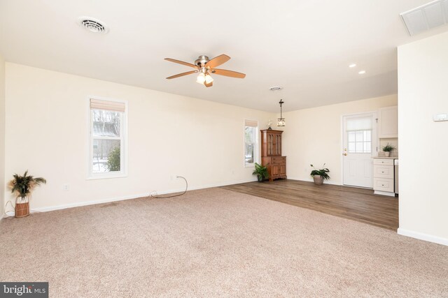 unfurnished living room with carpet flooring and ceiling fan