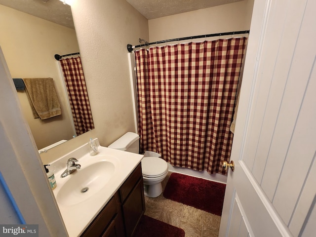 bathroom with vanity, curtained shower, toilet, and a textured ceiling