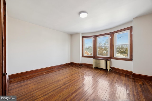 empty room with radiator and dark wood-type flooring