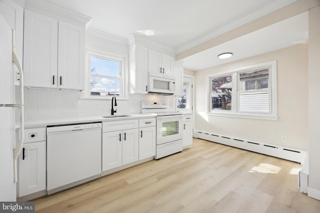 kitchen featuring baseboard heating, white appliances, white cabinets, decorative backsplash, and sink