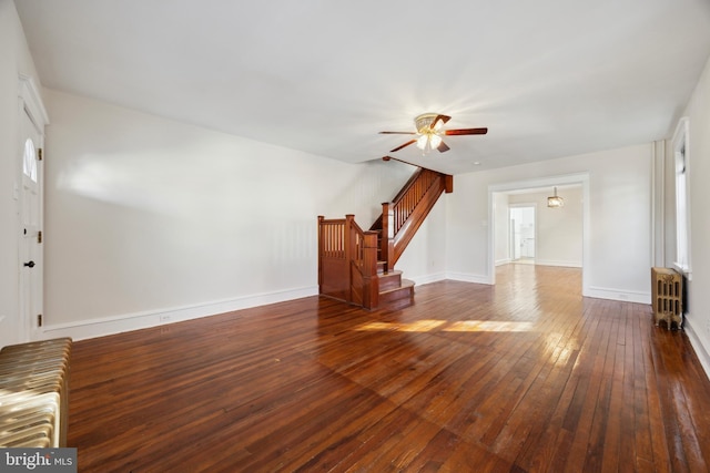 unfurnished living room featuring ceiling fan, dark wood-type flooring, and radiator heating unit