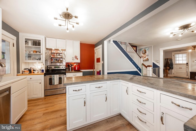 kitchen with stainless steel appliances, white cabinetry, and light wood-type flooring