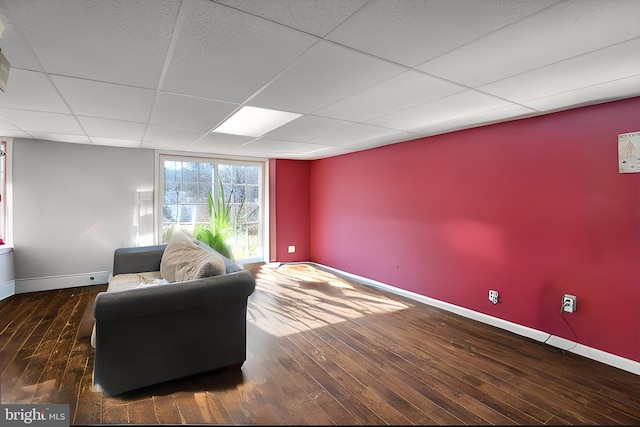 living area featuring dark hardwood / wood-style flooring and a drop ceiling