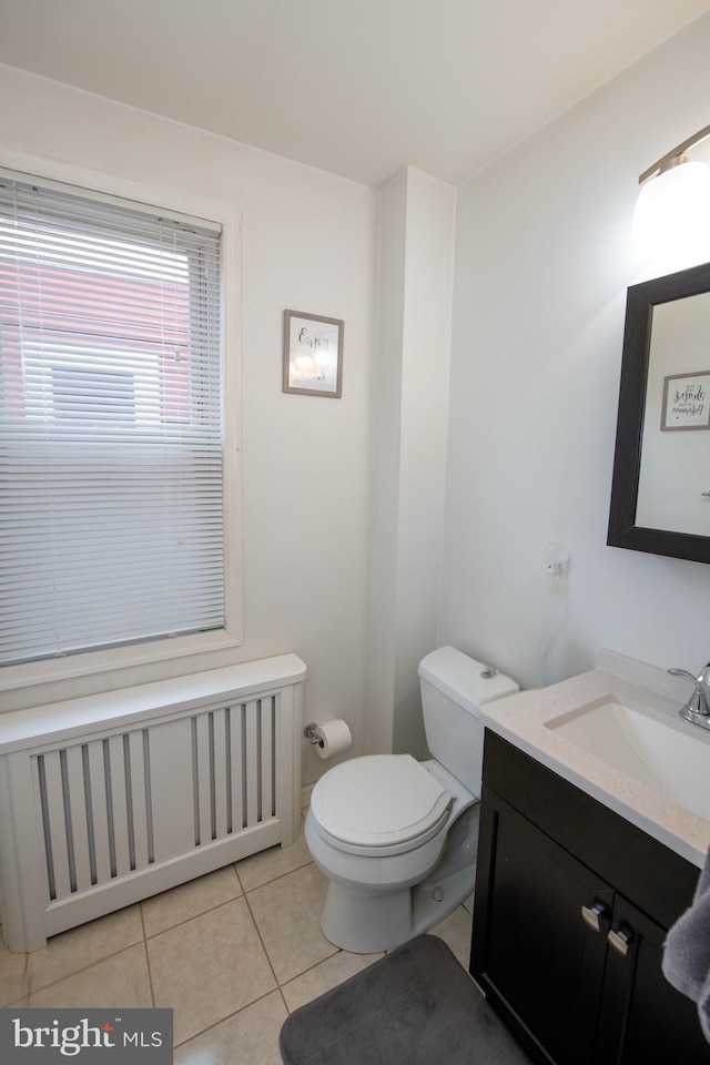 bathroom featuring toilet, vanity, tile patterned floors, and radiator heating unit