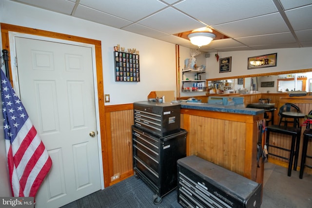 bar with wood walls and a drop ceiling