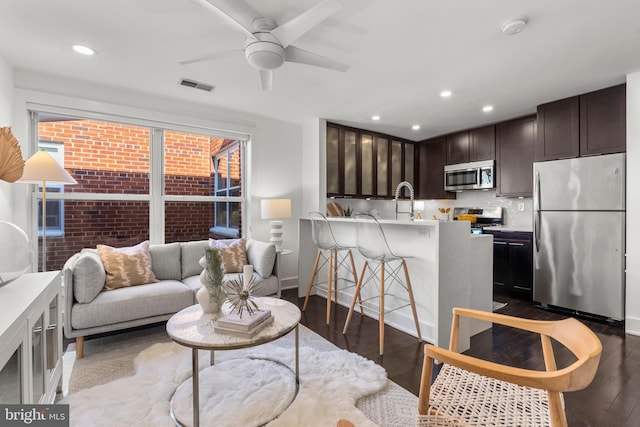 living room with dark wood-type flooring and ceiling fan