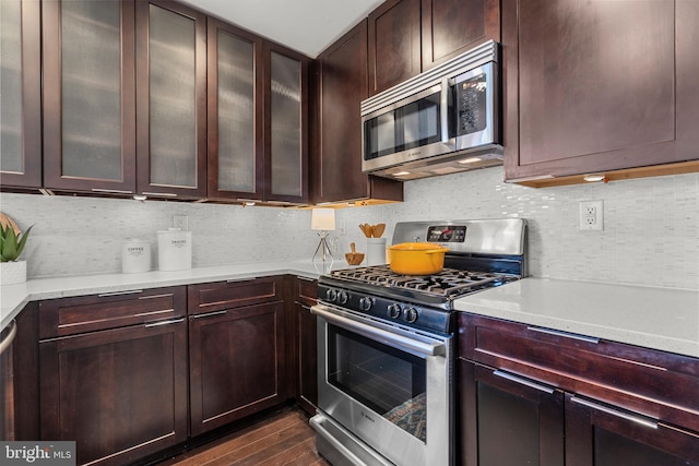 kitchen featuring dark hardwood / wood-style floors, stainless steel appliances, dark brown cabinets, and tasteful backsplash