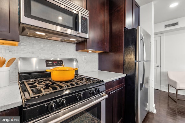 kitchen featuring tasteful backsplash, dark hardwood / wood-style floors, stainless steel appliances, and dark brown cabinetry