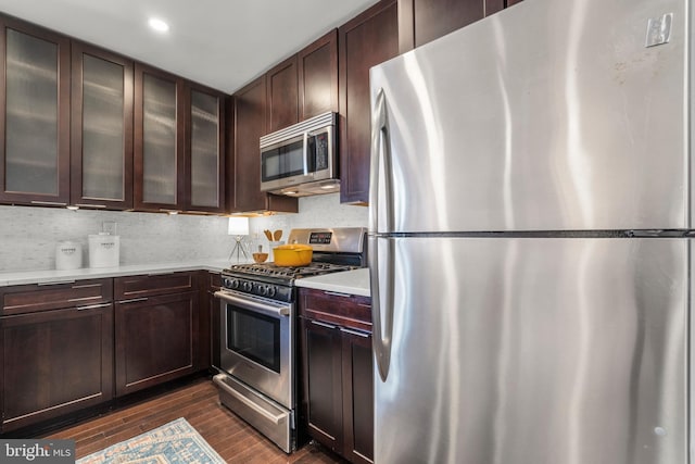 kitchen featuring tasteful backsplash, appliances with stainless steel finishes, dark hardwood / wood-style flooring, and dark brown cabinetry